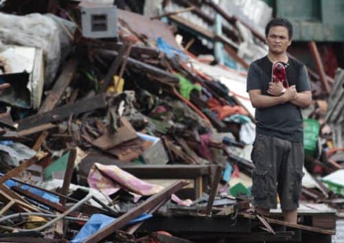 A resident surveys wreckage in Tacloban City. Picture: AP