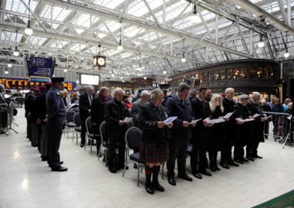 Servicemen and commuters at a service of remembrance at Glasgow Central Station. Picture: HEMEDIA