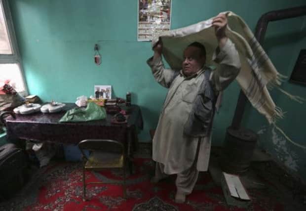 Zabulon Simintov dons his prayer shawl at his home. Picture: Reuters
