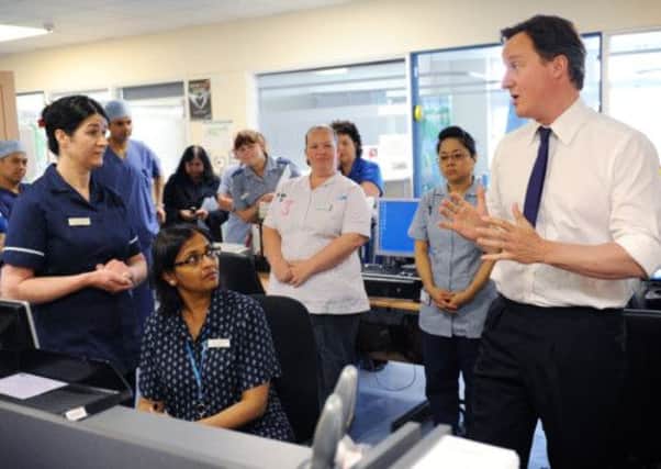 Prime Minister David Cameron gets his sleeves rolled up during a hospital visit. Picture: Getty Images