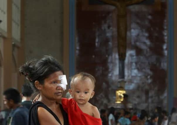 An injured mother and her son in a Catholic church which has been used as a temporary evacuation centre in Tacloban city. Picture: Reuters