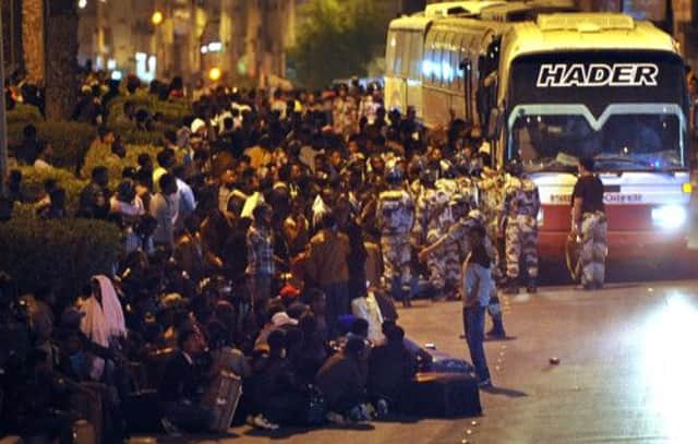 Illegal immigrants, rounded up by police, wait on buses in Riyadh, left and below, to deport them. Picture: Getty
