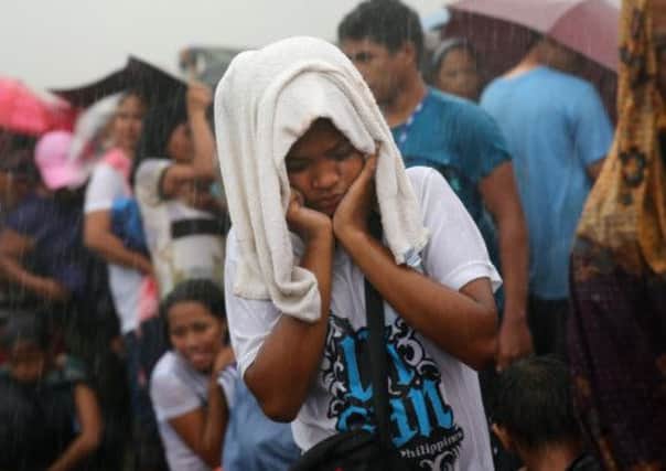 People queue in the rain for a rescue flight at Tacloban Airport. Picture: Getty