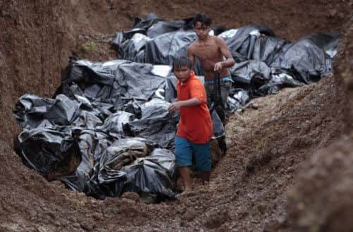 Workers bury the dead. Picture: AP