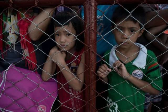 Typhoon victims wait in line to have a chance to board a flight to evacuate the area at Tacloban airport. Picture: Getty
