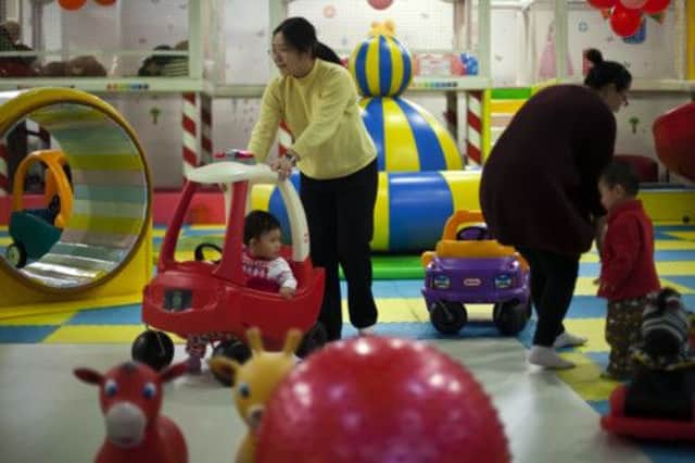 Mothers play with their only children at a shopping centres creche in Beijing. Parents have welcomed the easing of restrictions. Picture: AP