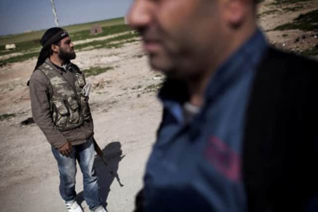 The Kurdish Popular Protection Units and Free Syrian Army stand guard at a check point in Syria. Picture: AP