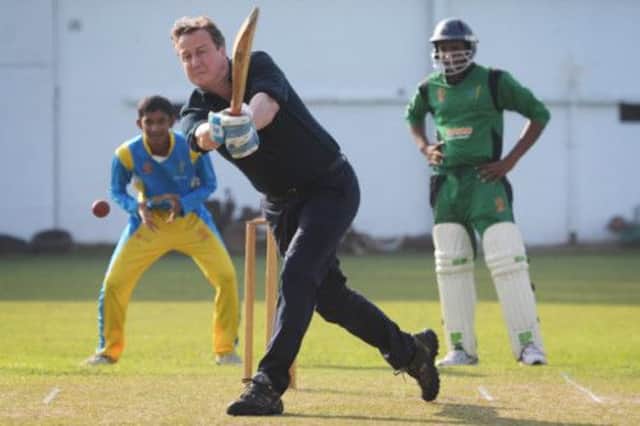 David Cameron was in to bat at the Sri Lankan national cricket school in Colombo, but faced criticism from cricketer Muttiah Muralitharan. Picture: PA