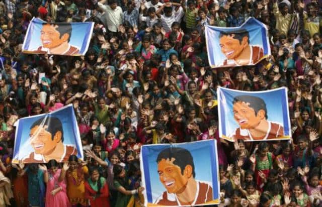 Fans hold up pictures of Sachin Tendulkar, who ended his 200th and final Test yesterday. Picture: AP