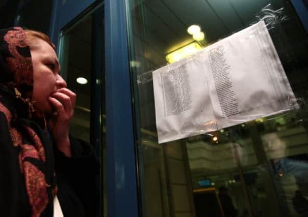 A woman reads a lists with the names of passengers who were aboard the Russian passenger airliner. Picture: AP
