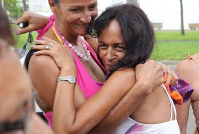 AnneMarie Collomp, right, hugs her sister on hearing the news of her husband's escape. Picture: AFP/Getty