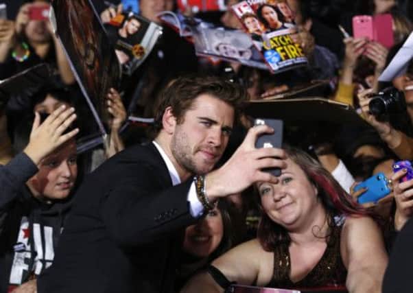 Actor Liam Hemsworth takes a 'selfie' with a fan. Picture: AP