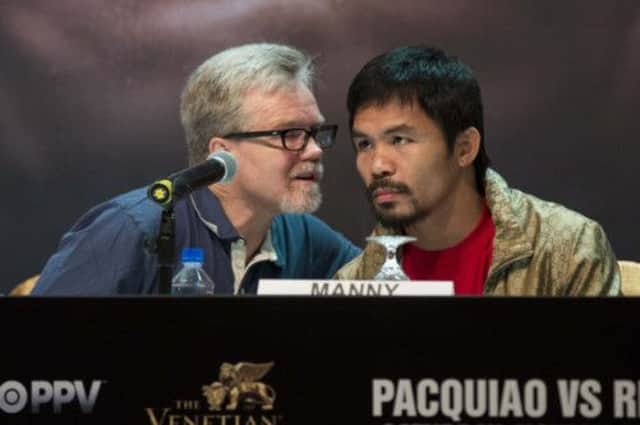 Freddie Roach has a quiet word with Manny Pacquiao during a media conference yesterday. Picture: Reuters
