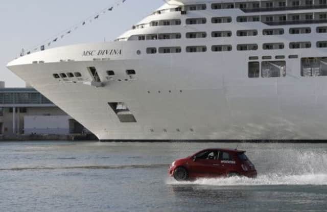 The floating cars welcomed the cruise ship into port. Pictures: AP