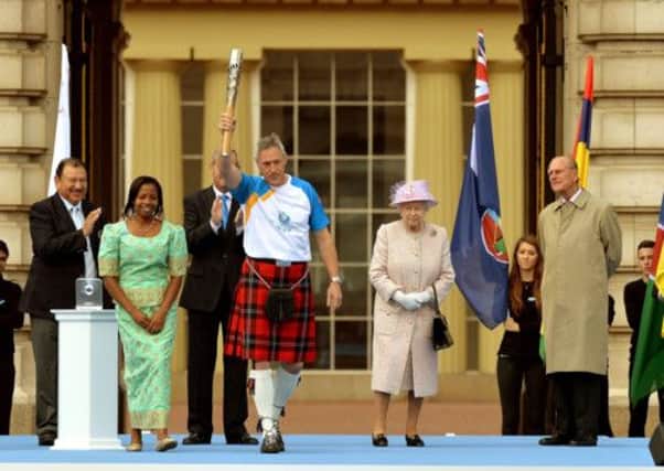 Alan Wells carries the Commonwealth Games baton, watched by the Queen Elizabeth II and Duke of Edinburgh. Picture: PA
