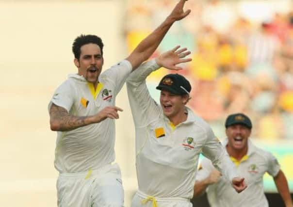 Mitchell Johnson of Australia celebrates with team mates Steve Smith and David Warner after dismissing Jonathan Trott of England. Picture: Getty