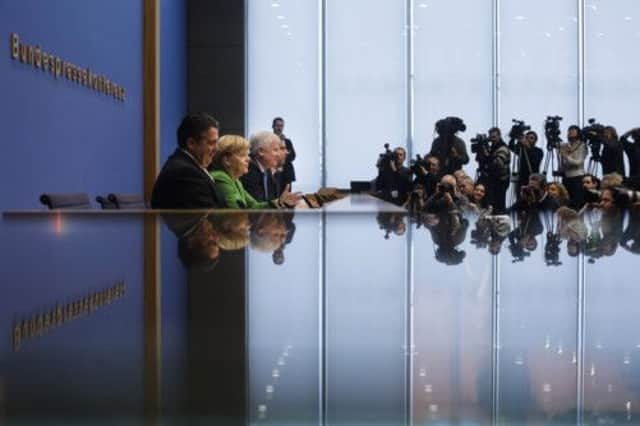 From left, Sigmar Gabriel, Angela Merkel and Horst Seehofer face the media. Picture: Markus Schreiber/AP
