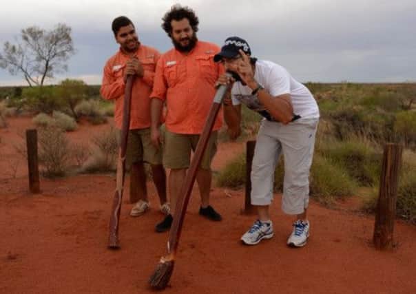 England's Monty Panesar tries playing a didgeridoo during a team visit to Ayers Rock. Picture: Getty Images