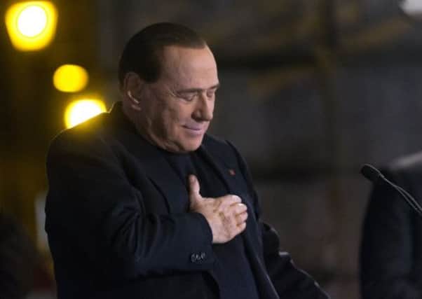 Silvio Berlusconi listens to his partys hymn at the end of a rally at his home in Rome yesterday. Picture: AP