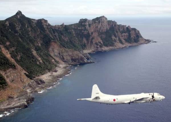 A Japanese aircraft flies over one of the disputed islands, which sit in oil- and gas-rich seas. Picture: Getty