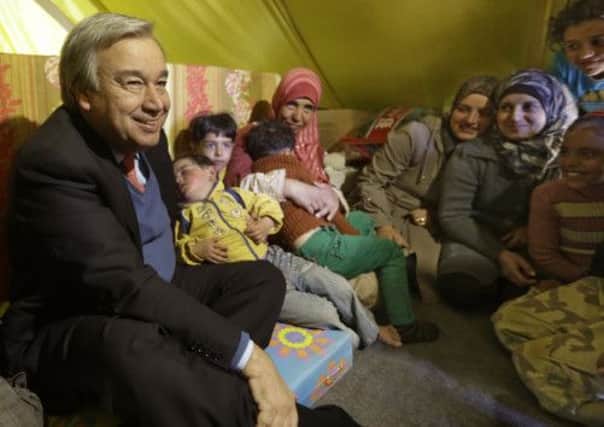 UNHCR chief António Guterres, left, meets a Syrian family on a visit to a refugee camp in the Lebanese town of Arsal. Picture: AP