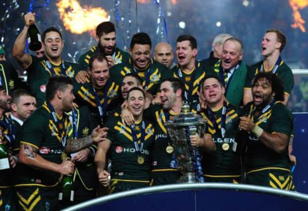 Cameron Smith (with trophy) and Billy Slater (centre) celebrate their emphatic win with their team-mates. Picture: PA