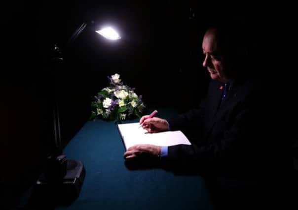 First Minister Alex Salmond  signs the book of condolence at Glasgow City Chambers. Picture: PA