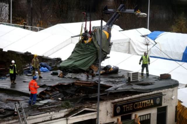 The helicopter wreckage is lifted from the roof of the Clutha bar. Picture: PA