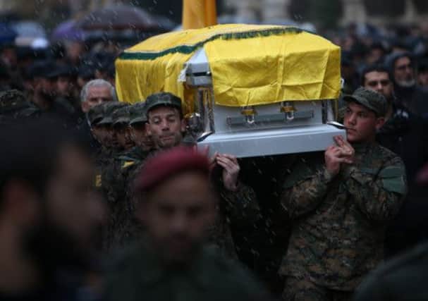 Hezbollah fighters bear the coffin of Mr Laqqis through the streets of Beirut in the rain. Picture: AP