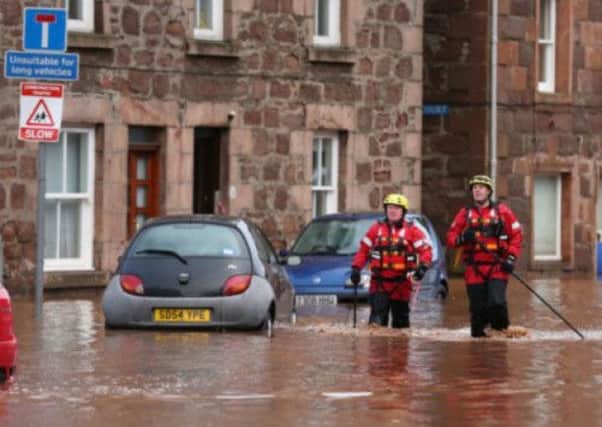 Emergency workers wading through floodwater in Stonehaven last December. Picture: PA