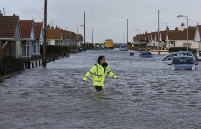An emergency rescue worker wades through floodwater in a residential street in north Wales. Picture: Reuters