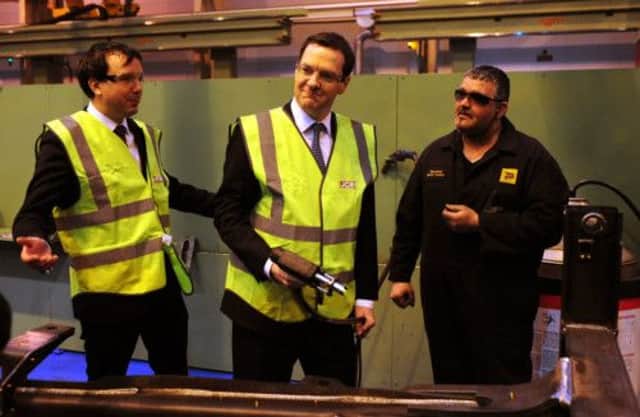 George Osborne seems pleased with his contribution as he visits JCB's Rocester plant in Staffordshire. Picture: PA