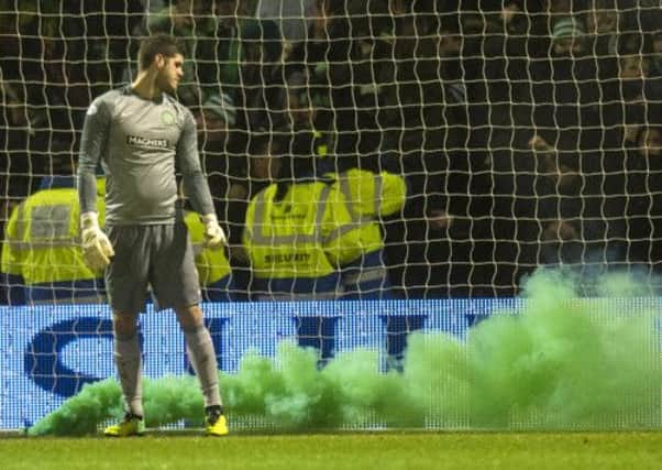 Fraser Forster's goalmouth is engulfed in green smoke from a flare. Picture: SNS