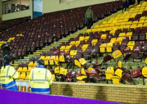 Stewards survey broken seats with Green Brigade stickers and terrorist slogans written on them after Celtic's visit to Fir Park on Friday. Picture: SNS