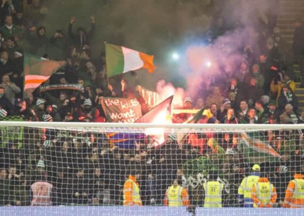 Celtic fans throw flares onto the pitch during Friday's game. Picture: PA