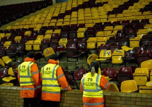 Stewards survey the damage to seats. Picture: SNS