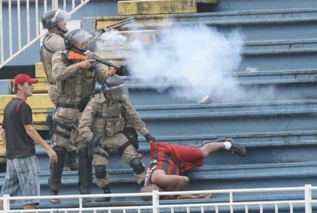Brazilian police fire rubber bullets and drag a Paranaense fan to safety during the trouble. Picture: Reuters