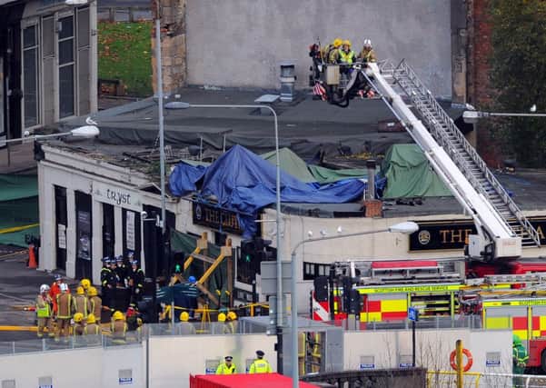 Workers at the site of the crash in Glasgow. Picture: Robert Perry