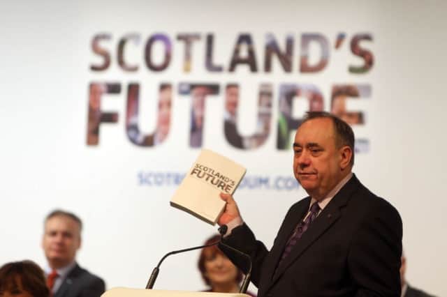 Alex Salmond brandishes the SNPs white paper while being quizzed by business leaders. Picture: PA