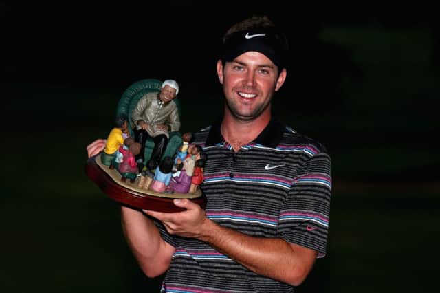 Scott Jamieson proudly shows off the trophy of the man himself after winning last year. Picture: Getty