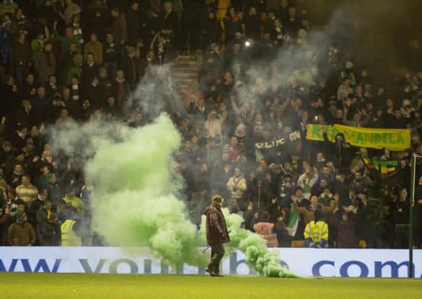 Celtic fans throw flares on to the pitch before the game at Fir Park. Picture: PA