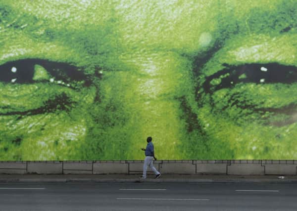 A man walks past a giant billboard bearing the face of Nelson Mandela in Pretoria. Picture: AP