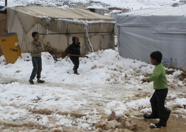 Syrian refugees in the snow at a camp in Lebanon after a winter storm swept across the region. Picture: Reuters