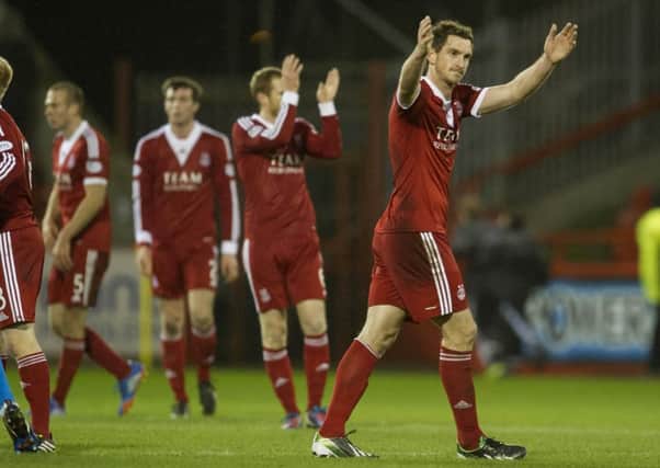 The Aberdeen players, led by Scott Vernon, applaud the fans at full-time. Picture: SNS