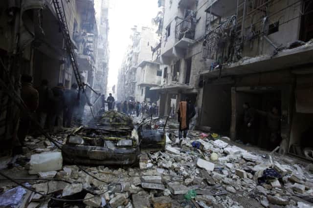 Syrians inspect yesterdays bomb damage on an Aleppo street. Picture: Reuters