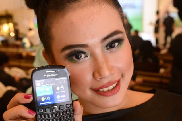 A model displays A Blackberry mobile phone with a Bank Permata programme during a ceremony in Jakarta. Picture: Getty