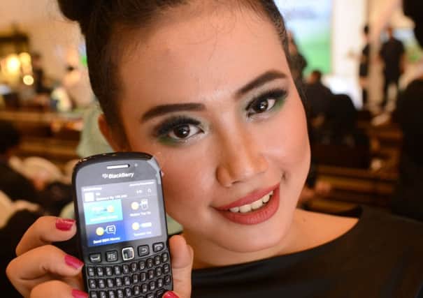 A model displays A Blackberry mobile phone with a Bank Permata programme during a ceremony in Jakarta. Picture: Getty