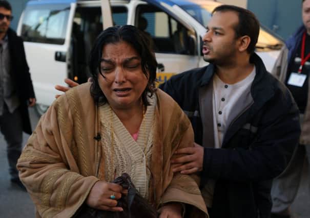 Fatima Khan, the mother of Dr Abbas Khan, is consoled by her other son Afroze. Picture: AP