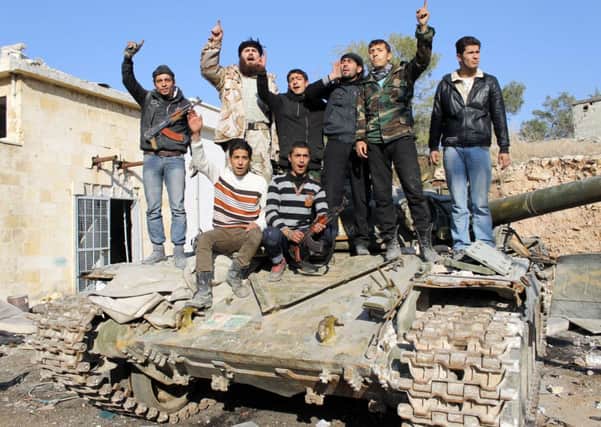 Rebel fighters with a tank confiscated from pro-regime fighters in the Syrian city of Aleppo. Picture: Getty