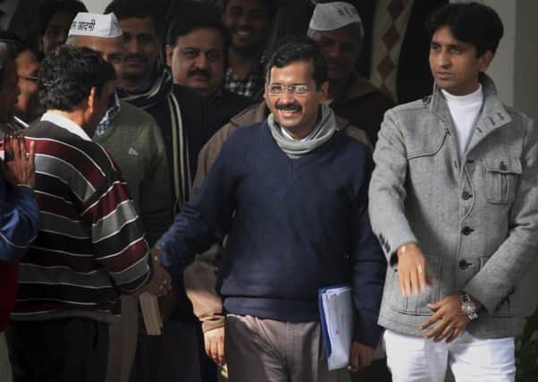 Arvind Kejriwal, centre, shakes hands with supporters. Picture: AP